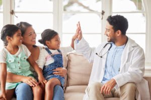 A smiling girl high-fives her family medicine provider after receiving positive test results.