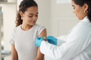 doctor applying a band-aid after injecting her patient during a consultation in the clinic