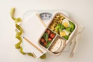 Nutrition and food management concept featuring balanced food options, a scale, and a measuring tape for weight management.