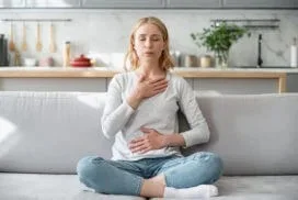 A woman practices a calming breathing exercise as part of anxiety treatment support from Abundance Health Care