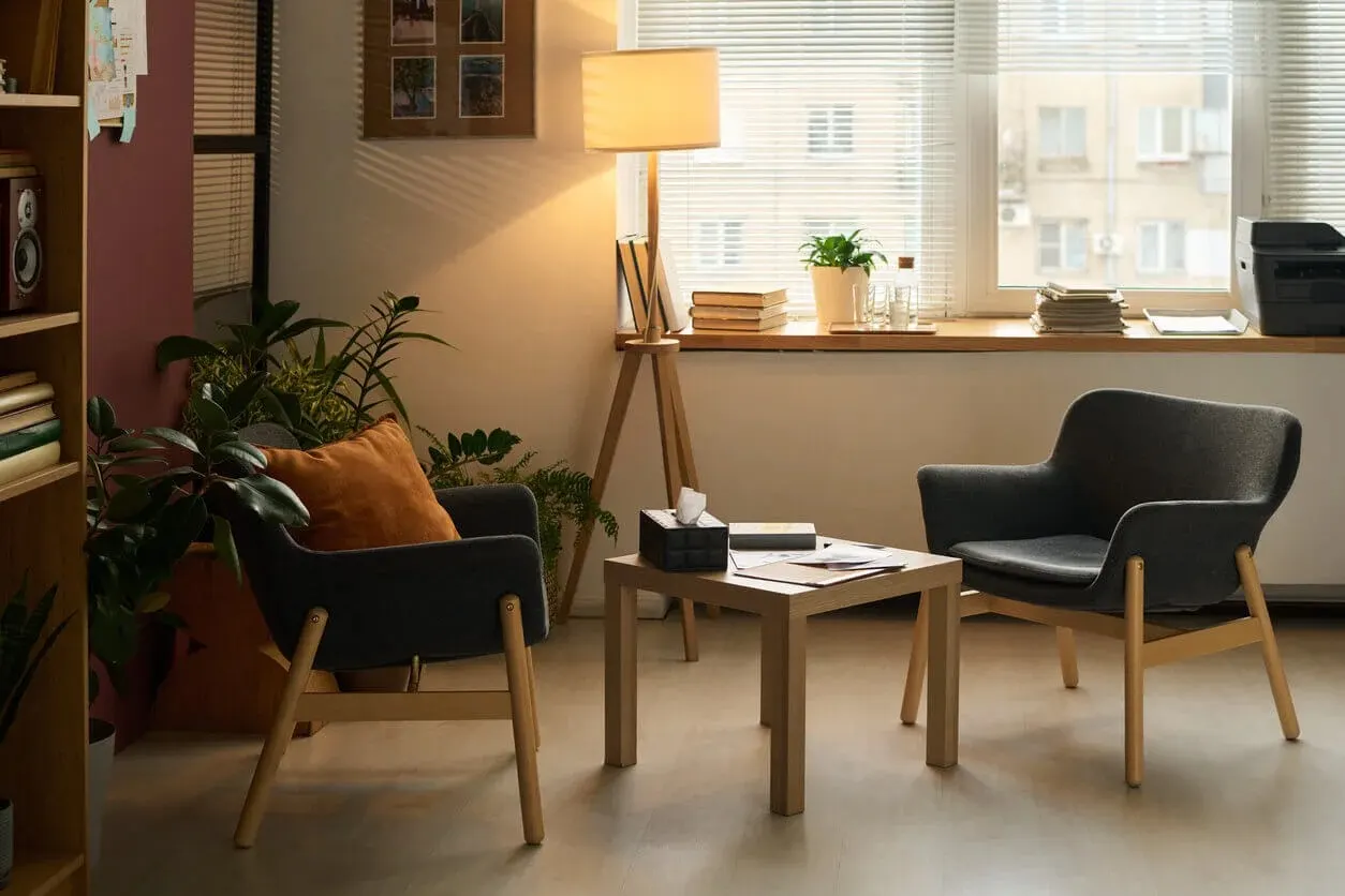 A calm, softly lit counseling office waiting area with comfortable seating, reflecting the welcoming environment at Abundance Health Care
