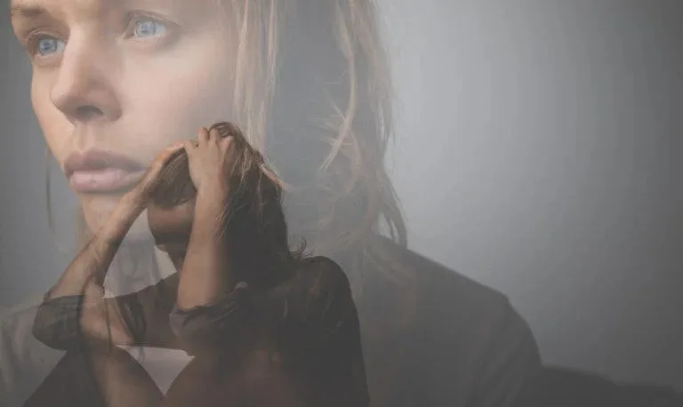 A young woman appears withdrawn and anxious while coping with a mental health illness, the kind of concern Abundance Health Care supports through primary care