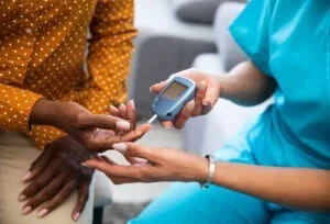 A provider performs a fingerstick diabetes test to help determine a patient's prediabetes prognosis at Abundance Health Care