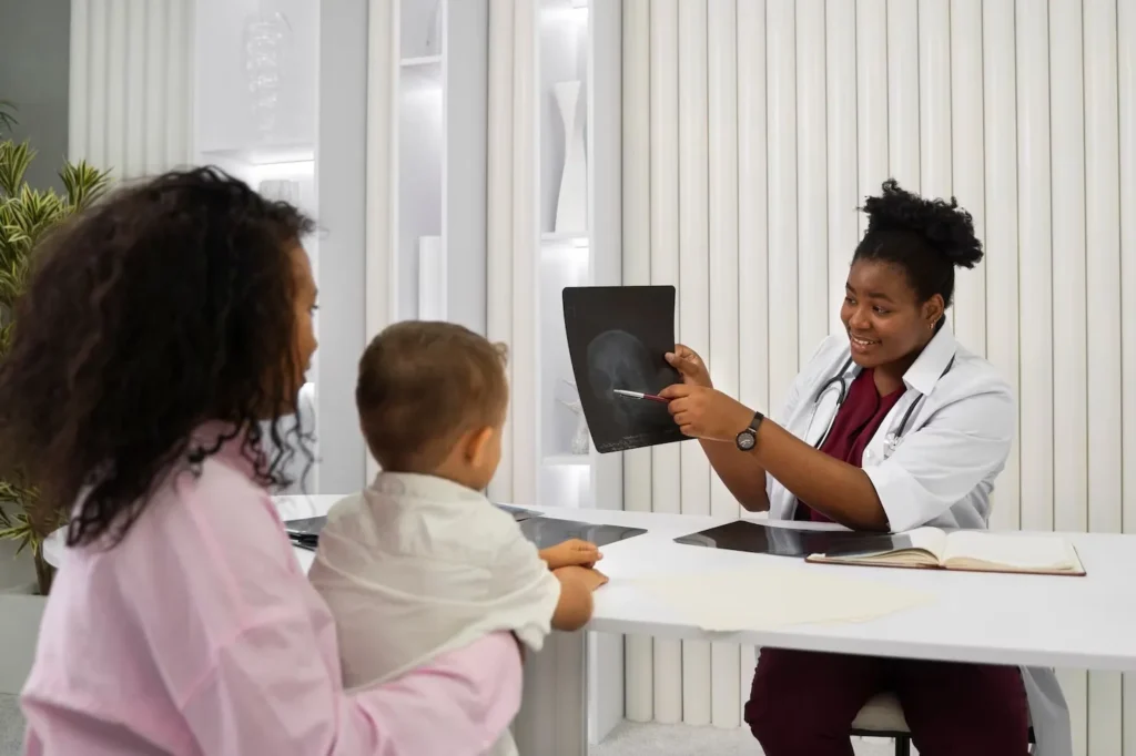 Doctor at Abundance Health Care reviewing an x-ray with a parent and child during a pediatric visit in Colorado Springs, CO