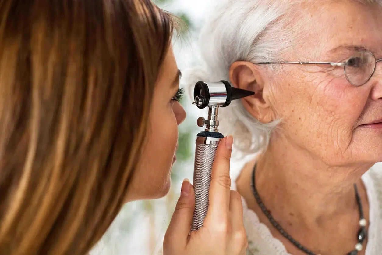 A provider performs an ear and hearing test on an elderly patient using an otoscope at Abundance Health Care