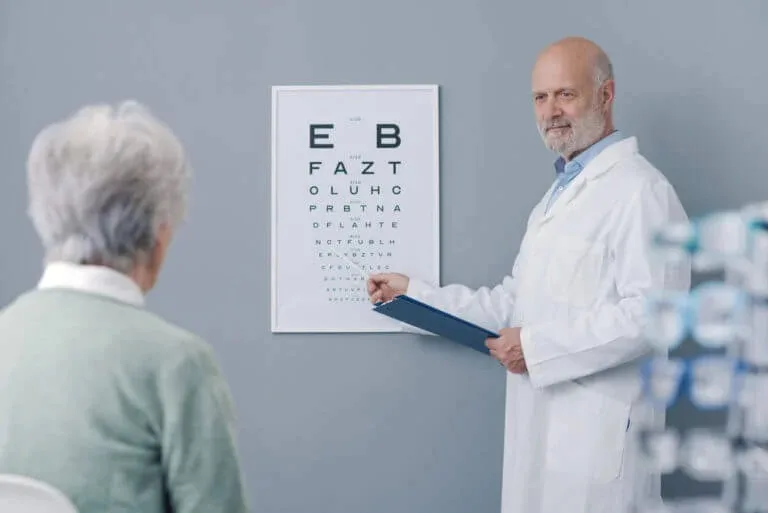 A provider reviews an eye chart with an elderly patient during a vision test at Abundance Health Care
