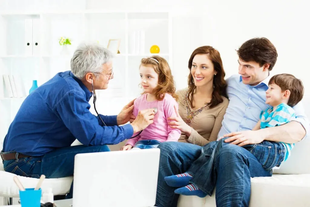 A family practice provider listens to a young girl's heartbeat with a stethoscope while her parents look on