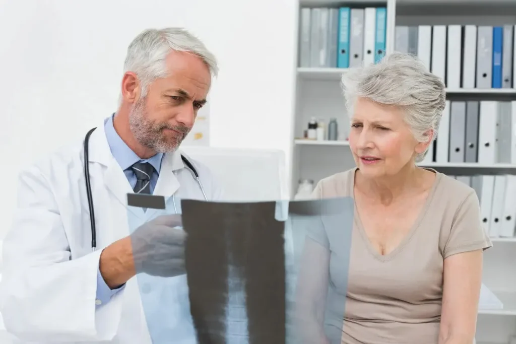 A geriatric care provider reviews a bone density x-ray with a senior patient at Abundance Health Care