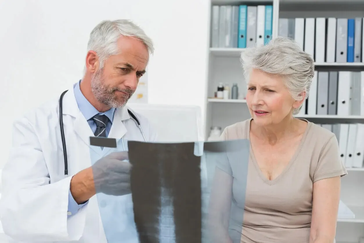 A geriatric care provider reviews a bone density x-ray with a senior patient at Abundance Health Care