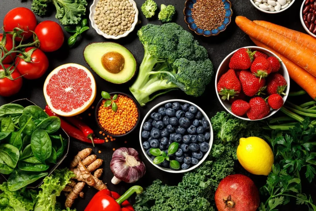 An assortment of fresh vegetables, fruits, and legumes arranged for a nutrition and food management plan