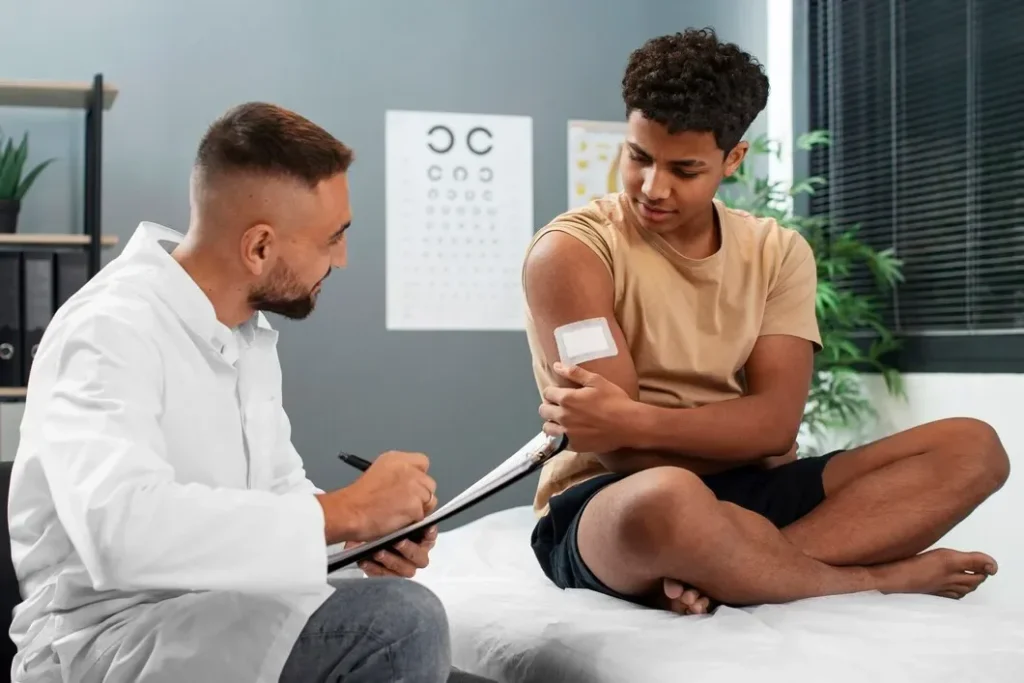 Doctor examining a teenage patient's arm during a pediatric checkup in Colorado Springs