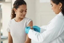 A healthcare provider administers a routine immunization shot to a patient