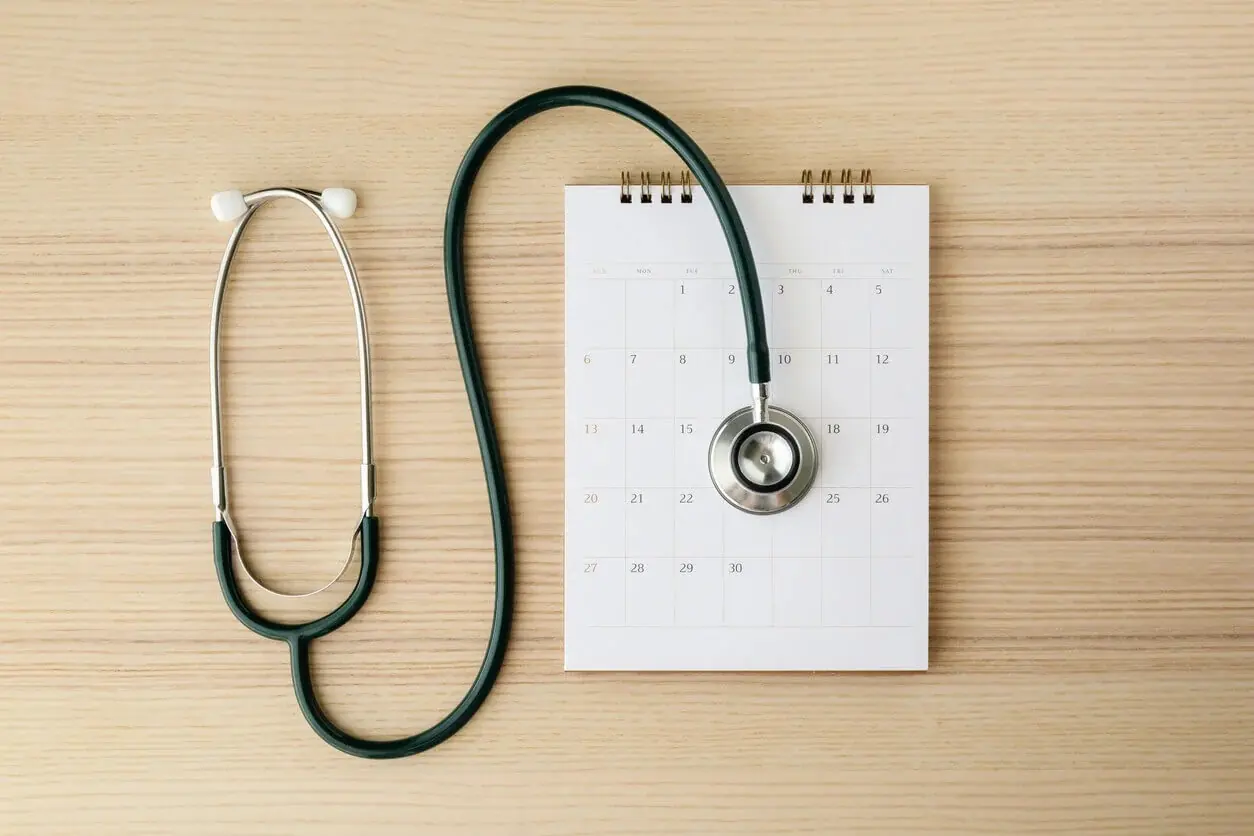 A stethoscope rests on a calendar page, representing scheduling an annual physical exam