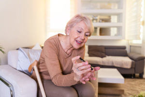 Woman checking blood sugar level by glucometer and test stripe at home